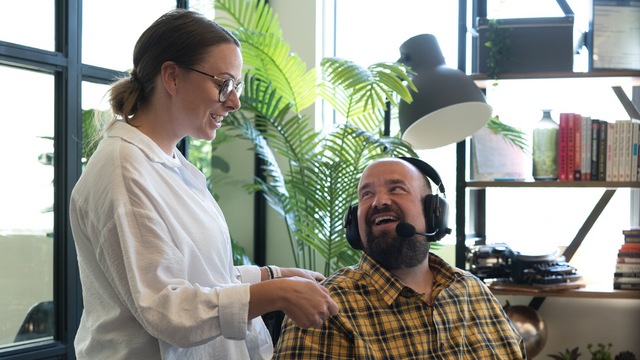 Picture of two coworkers smiling and laughing as they talk in an office