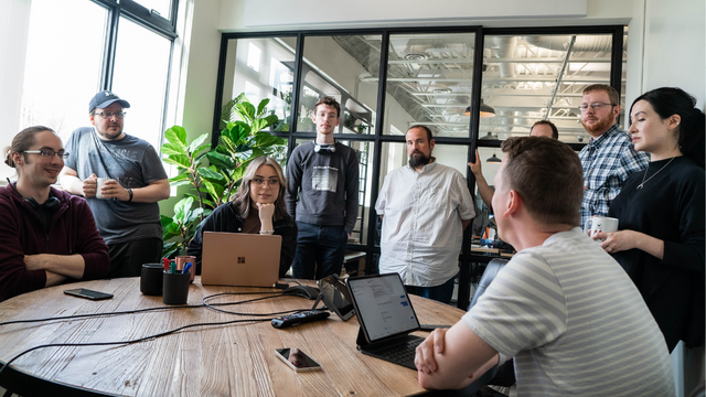 hiring an external IT company - Picture of the Clearbridge team in a meeting room having a meeting with technology